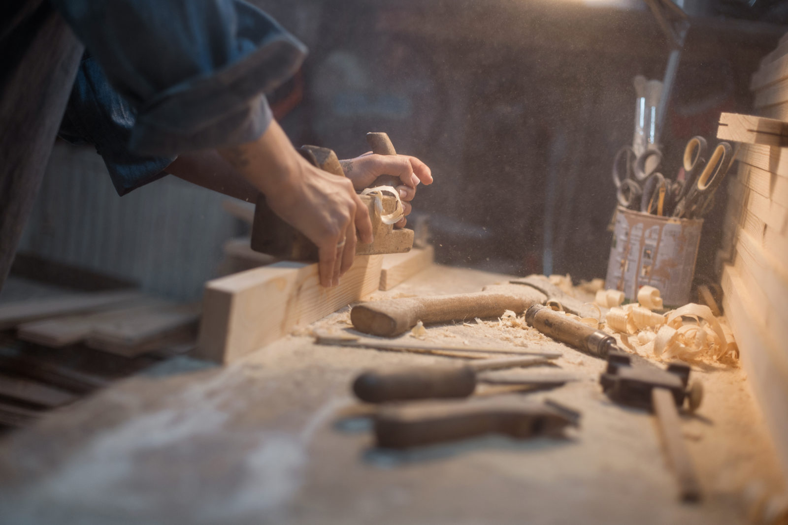 Handmade concept. Women's hands do the product of wood. Wood workshop with a tool and a lamp