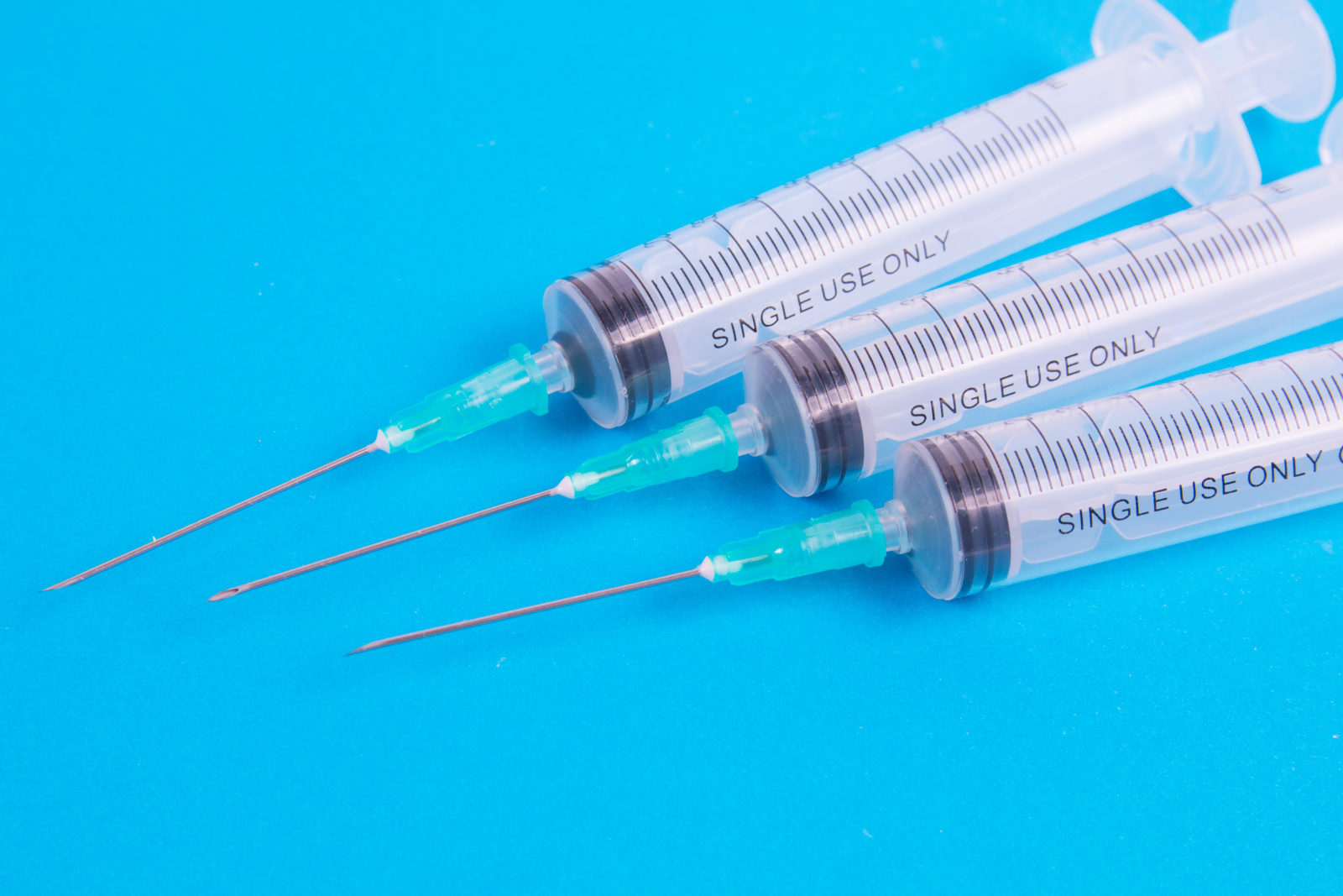 medical syringe on blue background. close-up