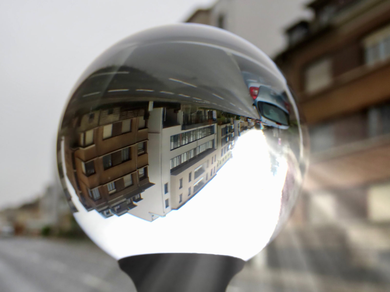Distorted image of a town street on a rainy day with rare ray of sun shining through crystal ball