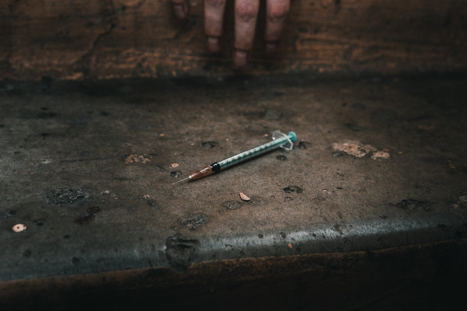 Heroin syringe on rough concrete